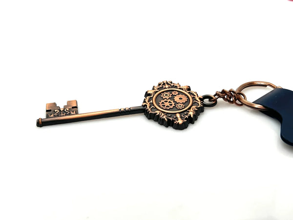 Universal Studios Toothsome Chocolate Emporium steampunk skeleton key metal keychain with exposed clockwork gears on a clean white backdrop