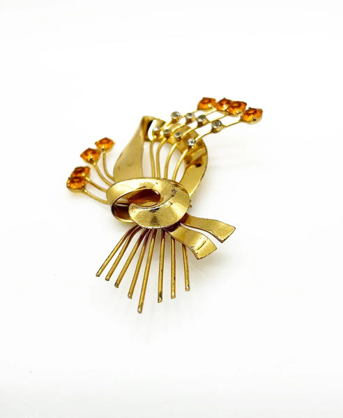 This is a massive Coro Sterling Floral Spray &amp; Ribbon Design brooch. Get mesmerized by the splendor of this vintage brooch, measuring just under 4 inches. The bouquet, intricately designed with a bow, boasts of four gold-toned lines adorned with round, citrine-orange stones of varying sizes.