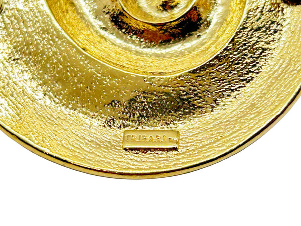 This stunning Trifari brooch captures the elegance of Art Deco design with its spiral seashell silhouette. Crafted in gold-tone metal, it features striking black enamel paired with creamy golden-sand enamel in a sophisticated moire finish.