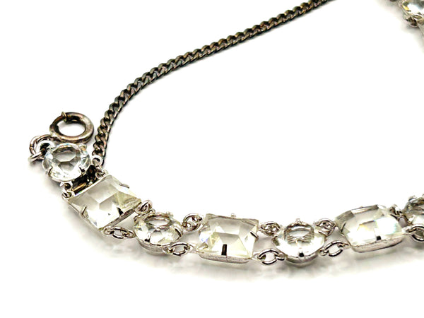 Vintage Art Deco style clear rhinestone geometric bracelet with alternating round and square-cut crystal links in a silver-tone setting on a plain white background