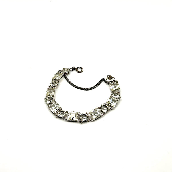 Vintage Art Deco style clear rhinestone geometric bracelet with alternating round and square-cut crystal links in a silver-tone setting on a plain white background