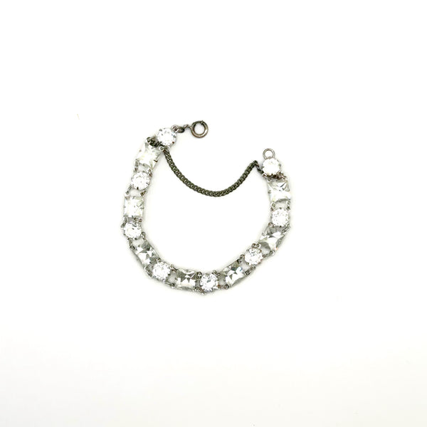 Vintage Art Deco style clear rhinestone geometric bracelet with alternating round and square-cut crystal links in a silver-tone setting on a plain white background