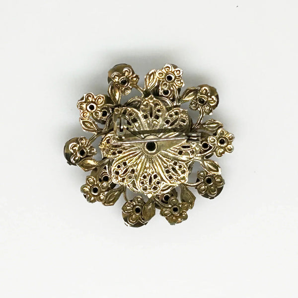 This dazzling brooch features a large octagonal purple stone at its center, surrounded by sparkling lavender and purple round stones. Its two-tiered design highlights the bezel-set centerpiece, making it truly eye-catching. With intricate details that showcase exceptional Czech craftsmanship,