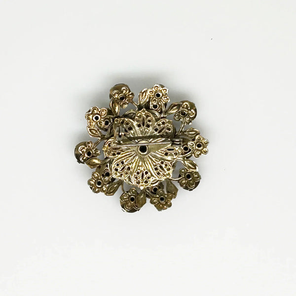 This dazzling brooch features a large octagonal purple stone at its center, surrounded by sparkling lavender and purple round stones. Its two-tiered design highlights the bezel-set centerpiece, making it truly eye-catching. With intricate details that showcase exceptional Czech craftsmanship,
