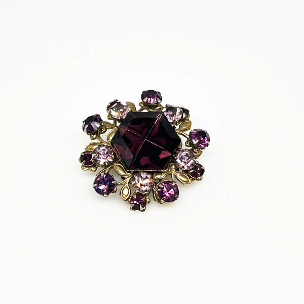 This dazzling brooch features a large octagonal purple stone at its center, surrounded by sparkling lavender and purple round stones. Its two-tiered design highlights the bezel-set centerpiece, making it truly eye-catching. With intricate details that showcase exceptional Czech craftsmanship,