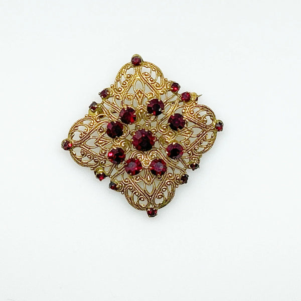 Intricate Vintage Gold Tone Brooch with Ruby Red Stones - Add timeless charm with this ornate brooch featuring deep ruby red stones. Perfect statement piece. Shop now!
