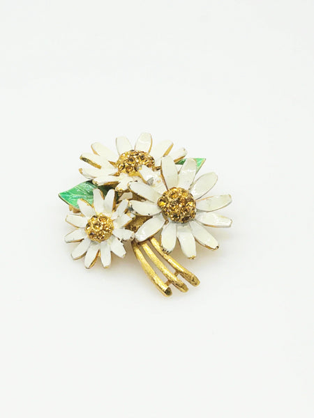 Add a touch of retro charm to your wardrobe with this darling daisy brooch! Featuring brightly painted petals and a sparkling rhinestone center, this 2" accessory is sure to put a smile on your face. And in good condition, it's ready for all your sunny adventures (and maybe a few rainy ones too). It is signed BSK and will take center stage in your wardrobe.