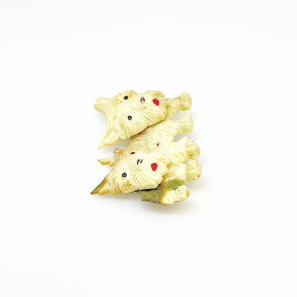 This stunning vintage brooch features a pair of West Highland White Terriers with tilting heads, perfectly capturing the playful nature of these beloved dogs. With exquisite fur texture, piercing black eyes, and adorable red tongues, this brooch is a true testament to the beauty of terriers. Measuring just under 1 1/2" wide and in excellent condition, it is a must-have for any dog lover's jewelry collection.