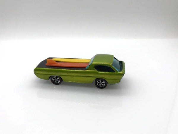 A small metallic green toy pickup truck with a yellow and orange striped bed, shown on a plain white studio background.