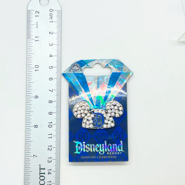 Celebrate a milestone moment with this stunning official Disney trading pin from the iconic 2015 Diamond Celebration collection. Featuring Mickey's signature ears adorned with sparkling crystal rhinestones, this collectible captures the magic of Disneyland's 60th anniversary in elegant style. 