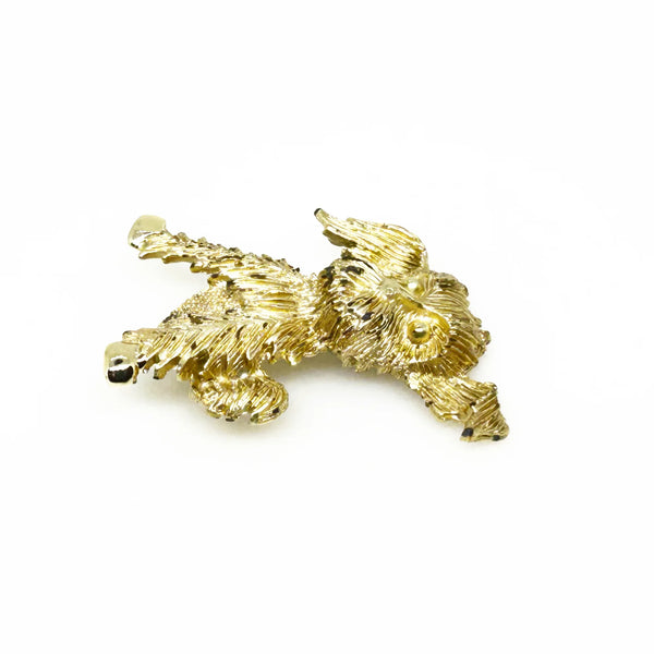 This charming vintage brooch depicts a playful dog caught mid-scratch, its attentive ear perked as if alert to intriguing sounds. The finely textured fur and detailed paws and eyes add refined character. Measuring 1.75", this piece remains in excellent condition, perfect for adding a touch of elegant whimsy to any ensemble. It's a delightful find for any animal lover or someone who appreciates unique, vintage jewelry.