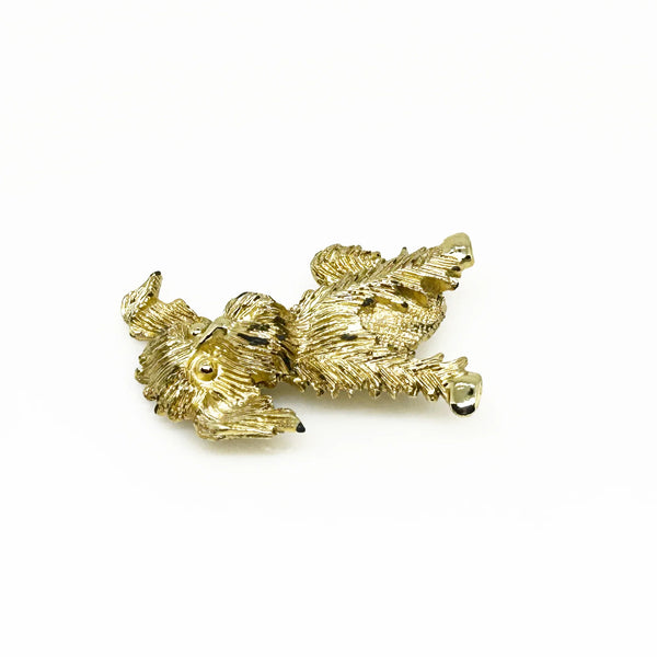 This charming vintage brooch depicts a playful dog caught mid-scratch, its attentive ear perked as if alert to intriguing sounds. The finely textured fur and detailed paws and eyes add refined character. Measuring 1.75", this piece remains in excellent condition, perfect for adding a touch of elegant whimsy to any ensemble. It's a delightful find for any animal lover or someone who appreciates unique, vintage jewelry.