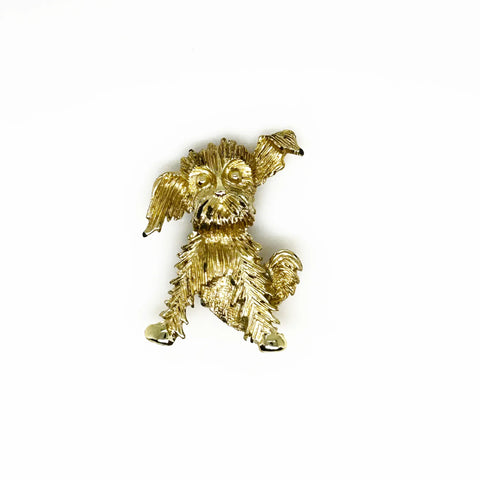 This charming vintage brooch depicts a playful dog caught mid-scratch, its attentive ear perked as if alert to intriguing sounds. The finely textured fur and detailed paws and eyes add refined character. Measuring 1.75", this piece remains in excellent condition, perfect for adding a touch of elegant whimsy to any ensemble. It's a delightful find for any animal lover or someone who appreciates unique, vintage jewelry.