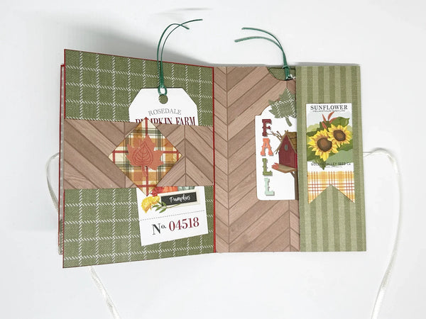 This one-of-a-kind handmade mini album captures the essence of fall – the most wonderful season! Showcasing rich shades of pumpkin, loden green, and cinnamon, it measures 4.75" tall by 3.75" wide and is secured with a soft off-white ribbon. 