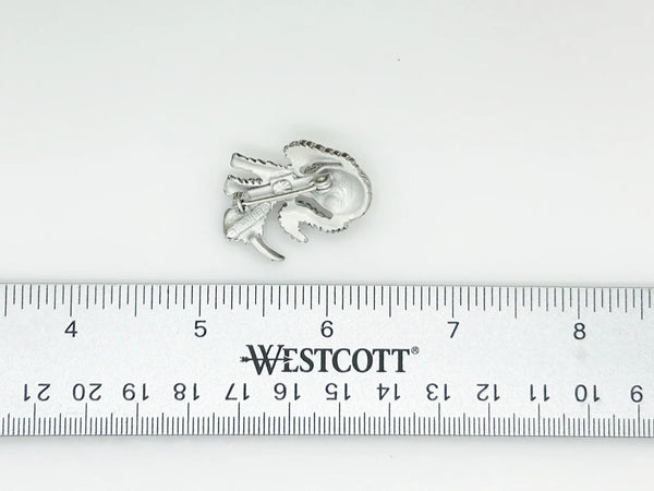 This vintage brooch shows an adorable, floppy eared puppy dog. He has bright green eyes and collar and wagging tail. He's just waiting for you! His coat is well detailed in silver tone metal. He or she measures 1 3/4" tall and is marked "Gerry's" in capitals on the white enamel back.