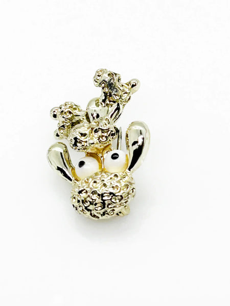 Stand out from the crowd with this adorable Vintage Tiny Gerry's Poodle Brooch with Big Eyes! Its textured gold tone metal and lifelike details make it a unique and charming addition to any outfit.