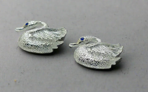 Indulge in the opulence of these exquisitely crafted pins adorned with intricate details and signed by the renowned Gerry's. Made from sleek silver tone metal, each pin boasts a textured body and lustrous wings. Mesmerizing bright blue stones serve as their striking eyes, while measuring just over 1" wide. In impeccable condition, these pins radiate elegance and sophistication.