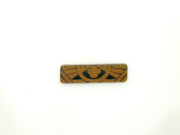 A vintage rectangular Art Deco revival bar brooch in the Pierre Bex style, featuring textured gold-tone metal sunburst rays, dark enamel details, and a central floral cloud medallion against a solid white background