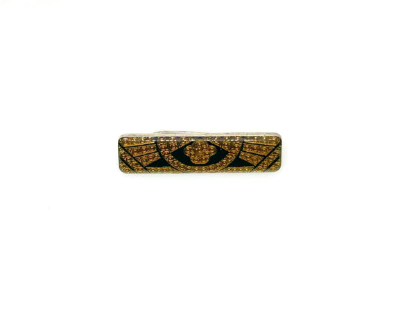 A vintage rectangular Art Deco revival bar brooch in the Pierre Bex style, featuring textured gold-tone metal sunburst rays, dark enamel details, and a central floral cloud medallion against a solid white background