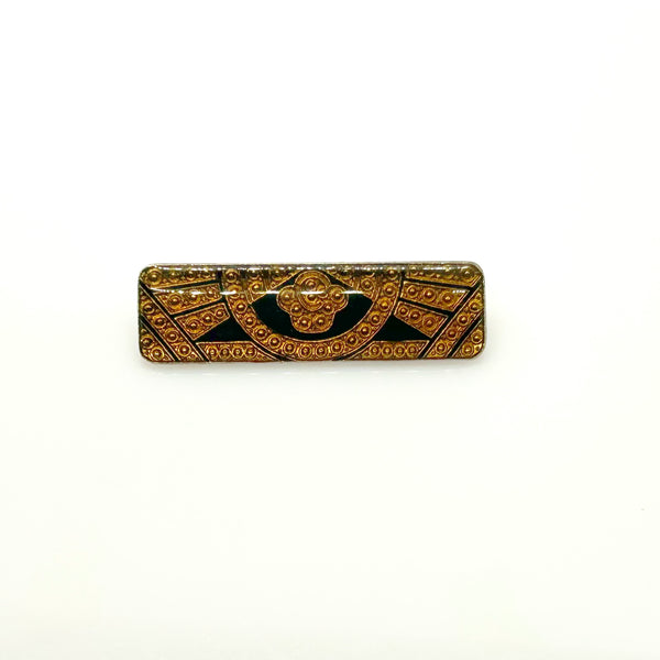 A vintage rectangular Art Deco revival bar brooch in the Pierre Bex style, featuring textured gold-tone metal sunburst rays, dark enamel details, and a central floral cloud medallion against a solid white background