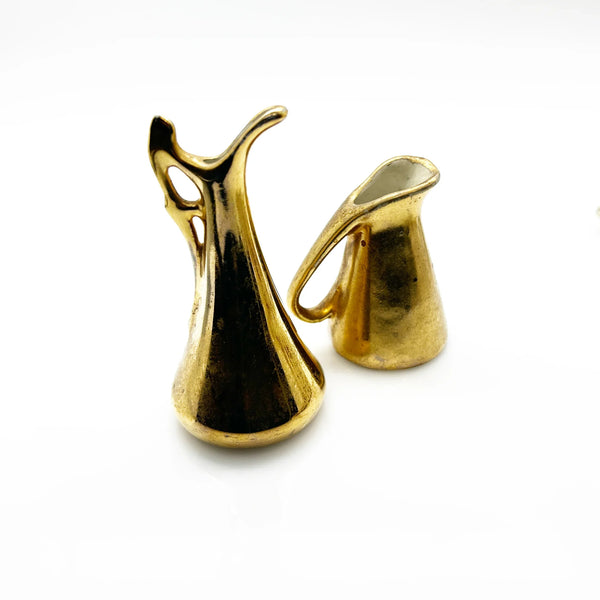 These lovely Victoria HU miniature pitchers are a wonderful addition to any vintage collection. This matched pair, produced in Czechoslovakia during the 1919-1940s era, embodies the refined aesthetic of Art Deco and Hollywood Regency design.
