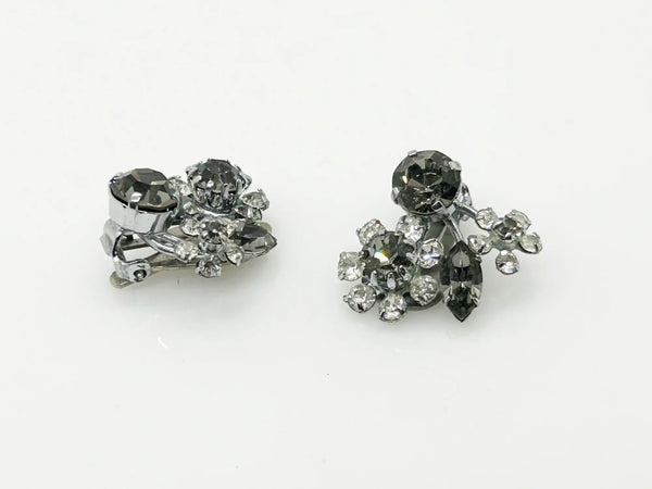 These vintage Sparkling Gray Austria Rhinestone Earrings captivate with their dazzling brilliance. Featuring a mix of gray and clear rhinestones expertly cut in marquise and round shapes, their intricate arrangement forms an elegant, eye-catching pattern