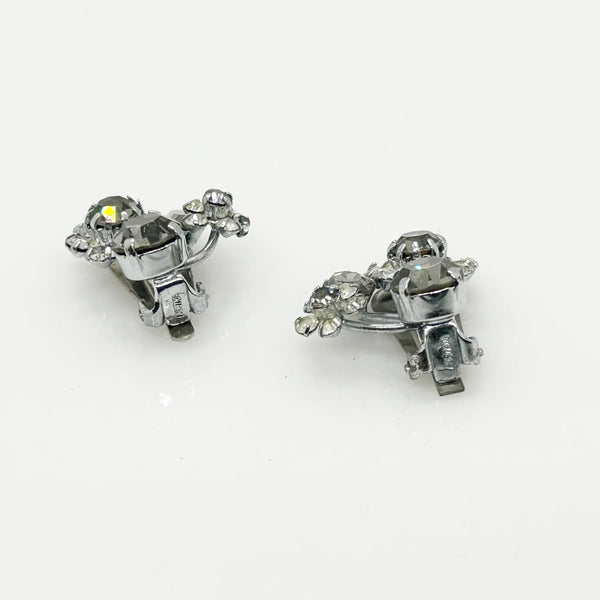 These vintage Sparkling Gray Austria Rhinestone Earrings captivate with their dazzling brilliance. Featuring a mix of gray and clear rhinestones expertly cut in marquise and round shapes, their intricate arrangement forms an elegant, eye-catching pattern