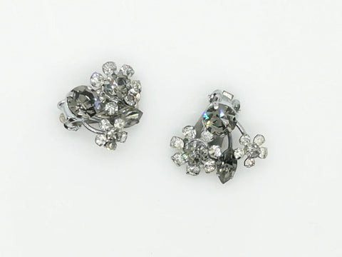 These vintage Sparkling Gray Austria Rhinestone Earrings captivate with their dazzling brilliance. Featuring a mix of gray and clear rhinestones expertly cut in marquise and round shapes, their intricate arrangement forms an elegant, eye-catching pattern