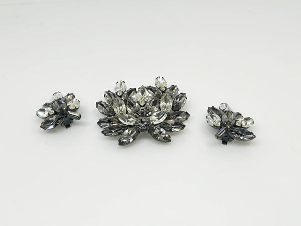 This is a gorgeous set of pin and earrings made with marquise and round shaped rhinestones in gray and clear. They are nestled in a layered, dark metal setting. The stones are standout bright and very sparking, great condition other than some wear on reverse. The earrings are clip on, hinge back.