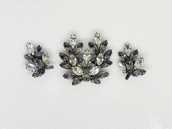 This is a gorgeous set of pin and earrings made with marquise and round shaped rhinestones in gray and clear. They are nestled in a layered, dark metal setting. The stones are standout bright and very sparking, great condition other than some wear on reverse. The earrings are clip on, hinge back.
