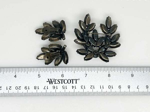 This is a gorgeous set of pin and earrings made with marquise and round shaped rhinestones in gray and clear. They are nestled in a layered, dark metal setting. The stones are standout bright and very sparking, great condition other than some wear on reverse. The earrings are clip on, hinge back.