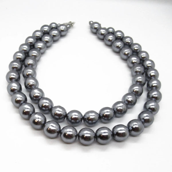 Get ready to make a statement with this stunning Vintage Double Strand of Luminous Smoky Faux Pearls Necklace! The glossy, rich gunmetal color adds a touch of elegance without being too flashy.