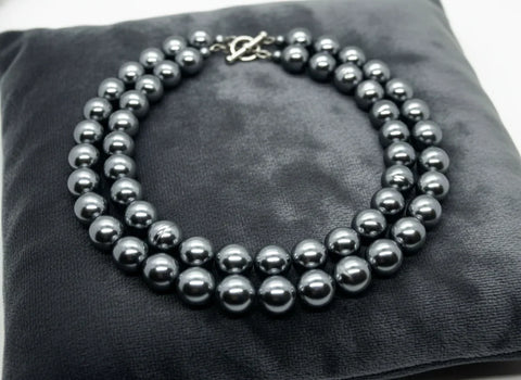 Get ready to make a statement with this stunning Vintage Double Strand of Luminous Smoky Faux Pearls Necklace! The glossy, rich gunmetal color adds a touch of elegance without being too flashy.