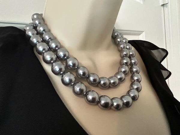 Get ready to make a statement with this stunning Vintage Double Strand of Luminous Smoky Faux Pearls Necklace! The glossy, rich gunmetal color adds a touch of elegance without being too flashy.