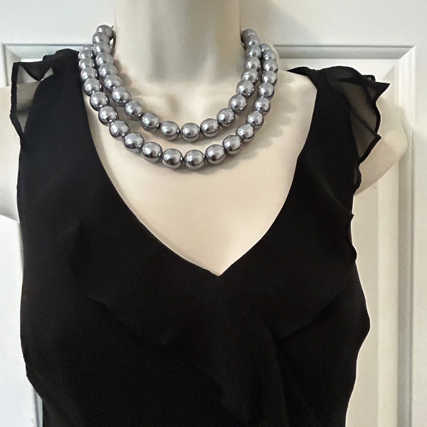 Get ready to make a statement with this stunning Vintage Double Strand of Luminous Smoky Faux Pearls Necklace! The glossy, rich gunmetal color adds a touch of elegance without being too flashy.