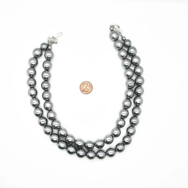Get ready to make a statement with this stunning Vintage Double Strand of Luminous Smoky Faux Pearls Necklace! The glossy, rich gunmetal color adds a touch of elegance without being too flashy.