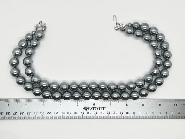 Get ready to make a statement with this stunning Vintage Double Strand of Luminous Smoky Faux Pearls Necklace! The glossy, rich gunmetal color adds a touch of elegance without being too flashy.