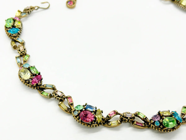 A stunning array of colors and shapes, carefully crafted into a one-of-a-kind piece. With a 4" extender for the perfect fit, this choker is sure to make a statement and add a touch of elegance to any outfit. Don't miss out on this unique and versatile addition to your jewelry collection!