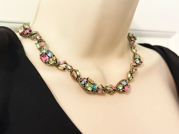 A stunning array of colors and shapes, carefully crafted into a one-of-a-kind piece. With a 4" extender for the perfect fit, this choker is sure to make a statement and add a touch of elegance to any outfit. Don't miss out on this unique and versatile addition to your jewelry collection!