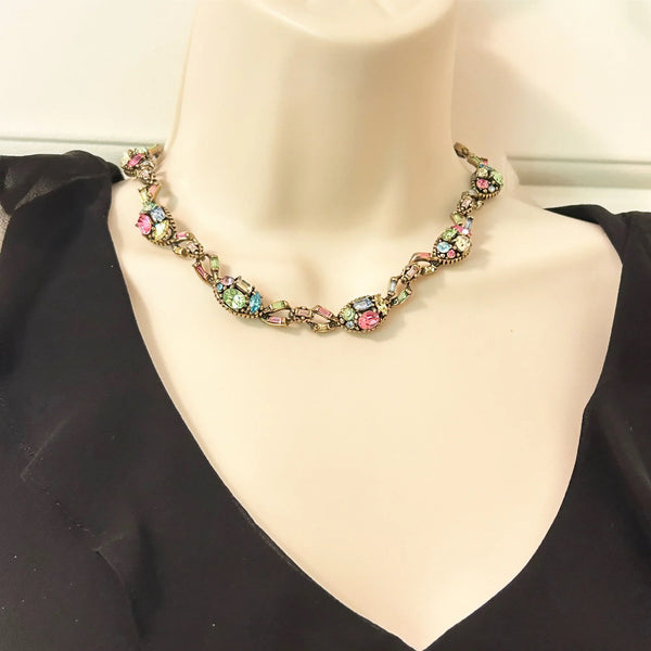 A stunning array of colors and shapes, carefully crafted into a one-of-a-kind piece. With a 4" extender for the perfect fit, this choker is sure to make a statement and add a touch of elegance to any outfit. Don't miss out on this unique and versatile addition to your jewelry collection!
