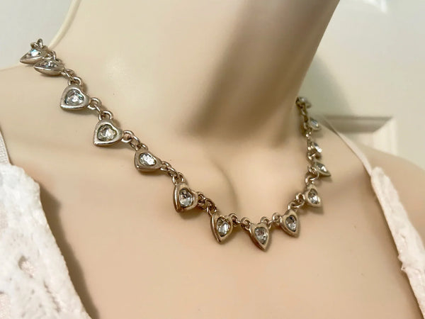 This charming necklace features heart shapes with sparkling round rhinestones at the center. Flip it over to reveal solid hearts with a sleek brushed finish—wear it whichever way suits your mood! Measuring 16" long, it’s secured with an adjustable whimsical flower clasp and a trusty lobster closure for a fun, flirty touch.