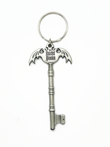 Silver key-shaped keychain with 'The Haunted Mansion' logo on a white background