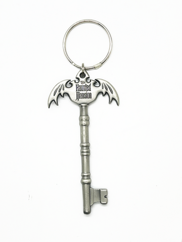 Silver key-shaped keychain with 'The Haunted Mansion' logo on a white background