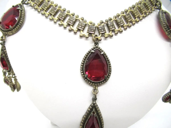 Experience breathtaking beauty with our exclusive Ornate Vintage Drop Necklace. Radiant red teardrop stones set in three long cascading drops, topped with two more tiers of red teardrops, create an eye-catching sparkle that will leave everyone awestruck. 