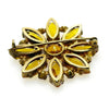This charming Antique Open Back Golden Stone Brooch is a dazzling tribute to vintage glamour. Sparkling faceted marquise stones with open backs catch the light from every angle, creating a rich, shimmering display centered around a brilliant round stone.