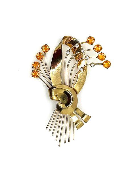 This is a massive Coro Sterling Floral Spray & Ribbon Design brooch. Get mesmerized by the splendor of this vintage brooch, measuring just under 4 inches. The bouquet, intricately designed with a bow, boasts of four gold-toned lines adorned with round, citrine-orange stones.