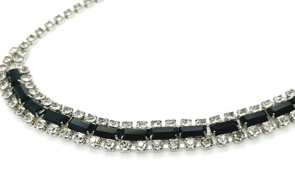 This is a beautiful vintage rhinestone necklace or choker set with a line of sideways baguettes in black paired with meticulously prong-set round white rhinestones on top and bottom.