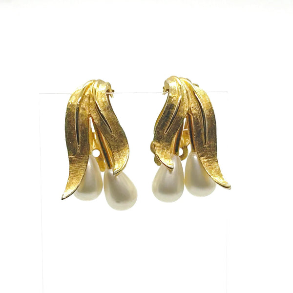 These elegant vintage clip-on Kramer earrings flow with understated grace, their brushed gold-tone leaves cradling luminous teardrop faux pearls.