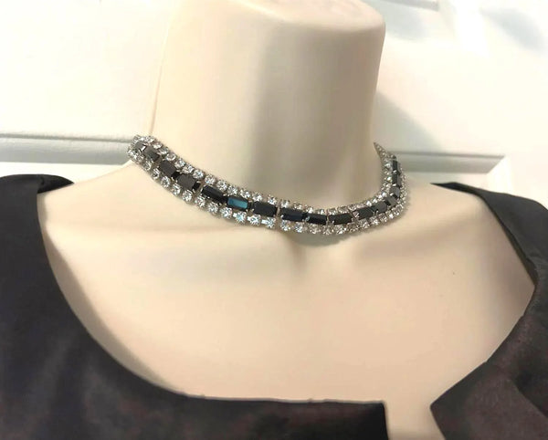This is a beautiful vintage rhinestone necklace or choker set with a line of sideways baguettes in black paired with meticulously prong-set round white rhinestones on top and bottom.