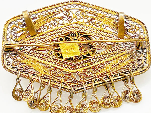 Vintage Israel Filigree Brooch/pendant with Tassels and Smokey Quartz center Stone.It has a geometric shape with tiny filigree drops at the bottom, and a large, faceted oval stone is the centerpiece. The metal is extremely intricate and detailed, both front and back.